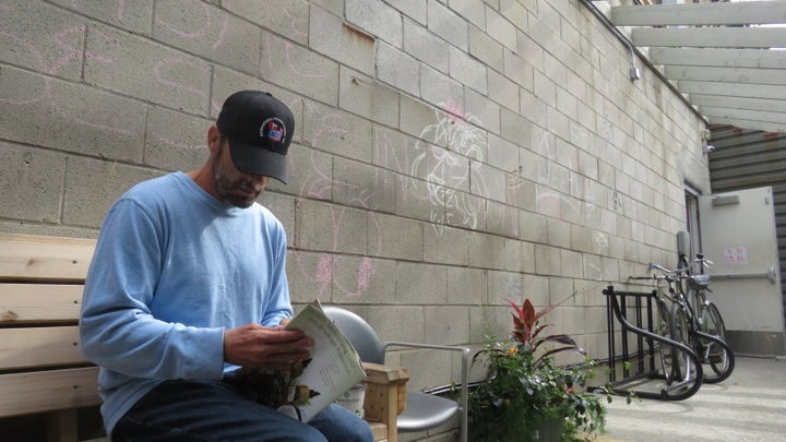 Kevin Drake reading a celebrity magazine.