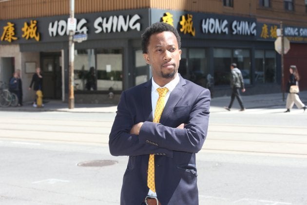 Emile Wickham posing in front of Hong Shing after winning his discrimination case with the Ontario Human Rights Tribunal.