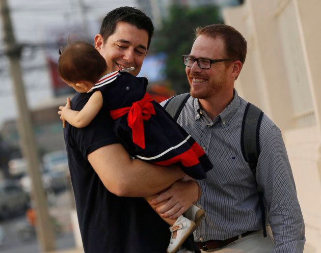 American Gordon Lake, right, and Spaniard Manuel Santos, left, walk with their baby Carmen at the Central Juvenile and Family Court in Bangkok, Thailand in 2016. They had a high-profile custody battle with a Thai surrogate mother who decided she wanted to keep the baby when she found out they were gay. Foreign surrogacy agreements are no longer legal in Thailand.