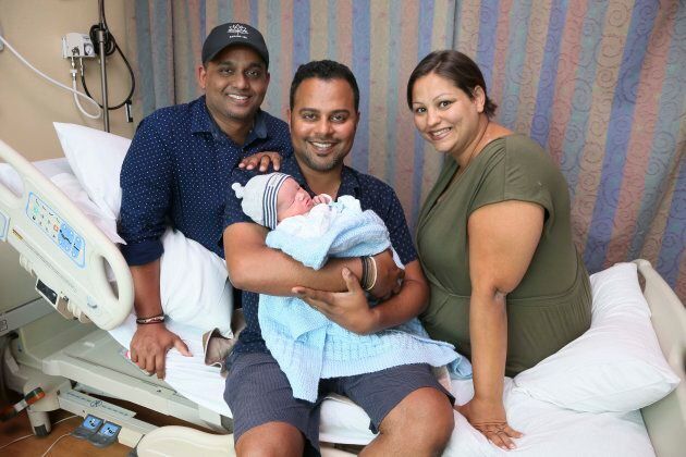 Asish Purushan holds baby Sidhnarth Jiwan Lall-Purushan with partner Krishneel Lall on the left and surrogate Mazyline McCarthy, at the Michael Garron Hospital, August 24, 2017.