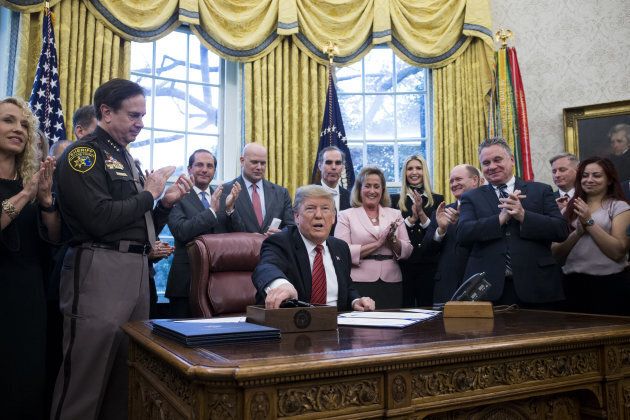 U.S. President Donald Trump hands out pens after signing anti-human trafficking legislation in the Oval Office at the White House in Washington, D.C. on Jan. 9, 2019.