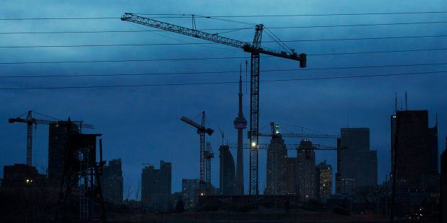 Construction cranes along the skyline in Toronto, Dec. 6, 2012. The slowdown in Canada's housing market will get worse before it gets any better, a new analysis predicts, because the country is about to be flooded with a