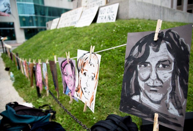 Portraits of some of the victims of the Lac-Mégantic disaster hang on a line during the a vigil held by 350 Maine and Sierra Club Maine in 2015.