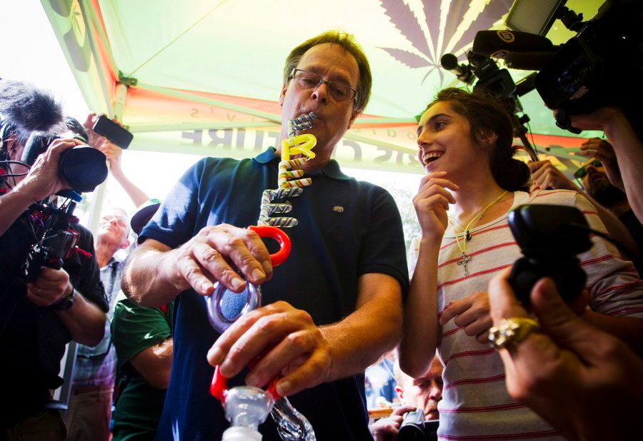 Marijuana activist Marc Emery smokes from a bong with the words "Freedom" on it during a party in downtown Vancouver on Aug. 17, 2014.