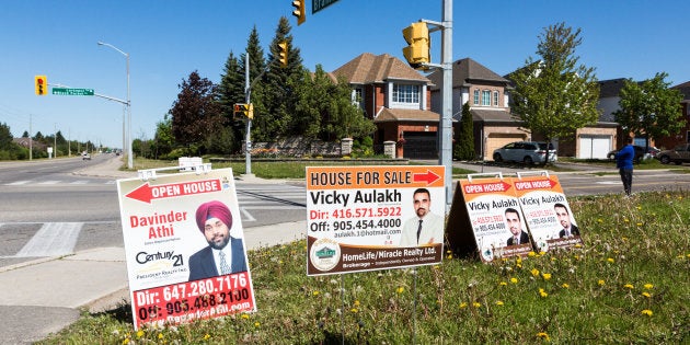 Open house signs on the side of a road in Brampton, Ont., Sat. May 20, 2017.