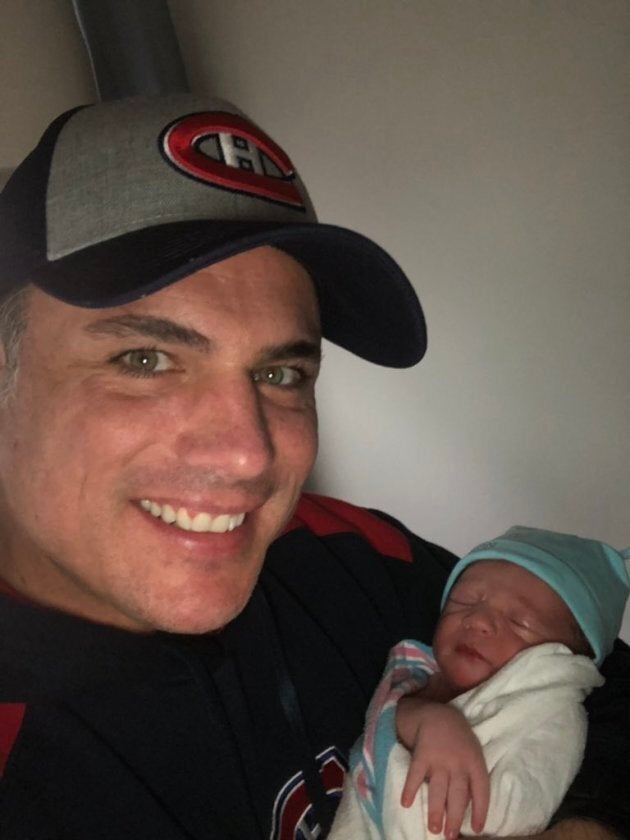 Patrick Brazeau holds his newborn son.