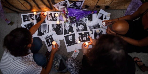 Friends of 18-year-old Danforth shooting victim Reese Fallon, leave candles on pictures of their friend Reese at a makeshift memorial remembering the victims of a shooting on Sunday evening on Danforth, Ave. in Toronto on July 23, 2018.