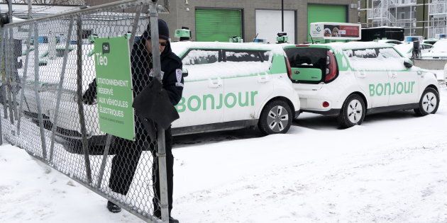 A security guard closes the gate of a parking lot of Teo Taxi in Montreal on Jan. 29, 2019. Montreal's Teo Taxi, which sought to take on Uber with a fleet of electric vehicles, has halted operations and laid off all its drivers.
