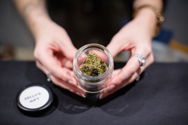 A salesperson displays a jar of cannabis at the Potorium dispensary in Nelson, B.C. on Nov. 7, 2018.