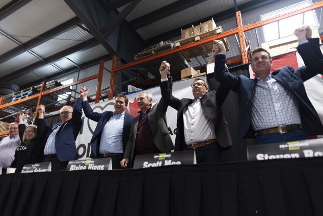 Various politicians including Conservative Leader Andrew Scheer Saskatchewan, Saskatchewan Premier Scott Moe, and New Brunswick Premier Blaine Higgs hold hands at the end of a pro-pipeline rally at IJACK Technologies Inc. near Moosomin, Sask., on Feb. 16, 2019.