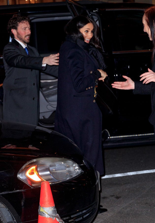 Meghan wore a long, navy coat with black accessories.