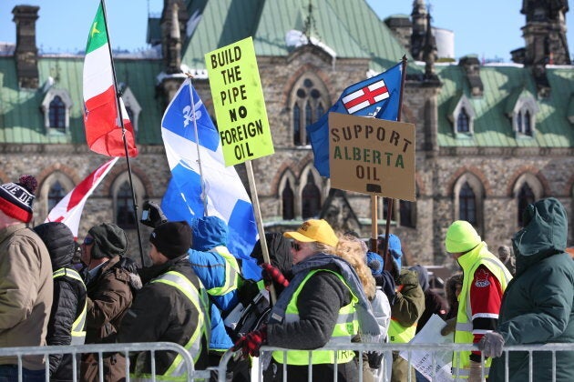 Supporters hold signs during a United We Roll Convoy pro-pipeline rally in Ottawa on Feb. 19, 2019.