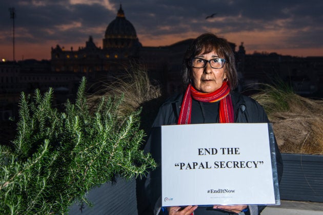 Evelyn Korkmaz, a victim from Canada, holds a sign with her message to Pope Francis on Feb. 18, 2019, in Rome.