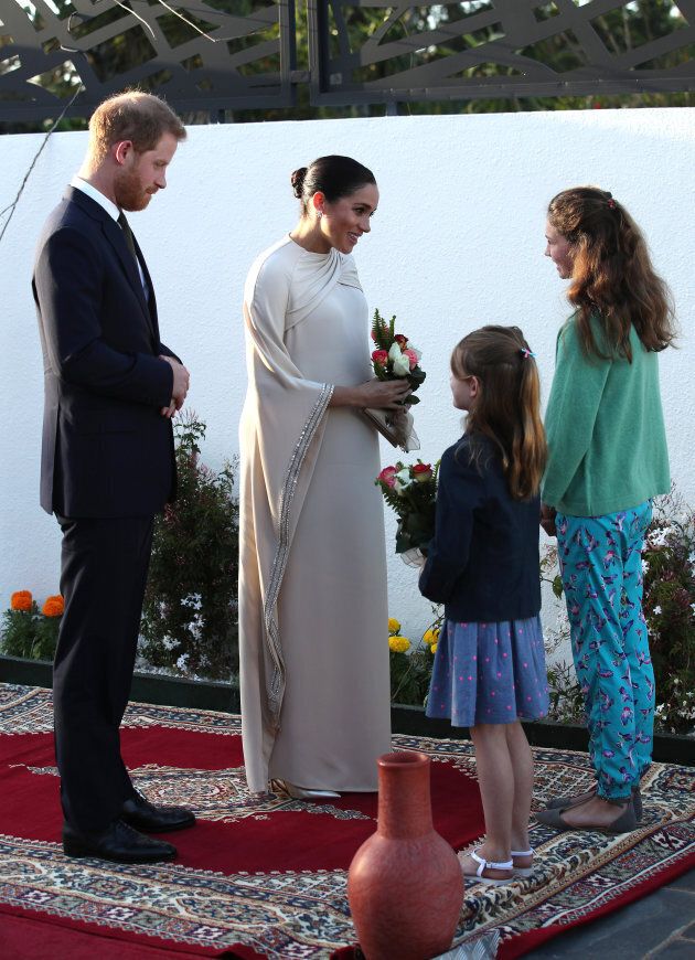 Harry and Meghan are greeted by the British ambassadors' daughters Orla Reilly, 12, and Elsa, eight, at a reception in Rabat.