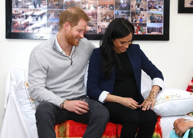 Harry and Meghan admiring the henna tattoo.