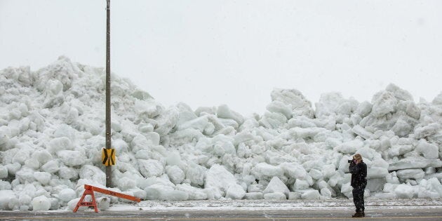 A man photographs a massive build-up of ice that was pushed onto the shore in Fort Erie, Ont., February 25, 2019.