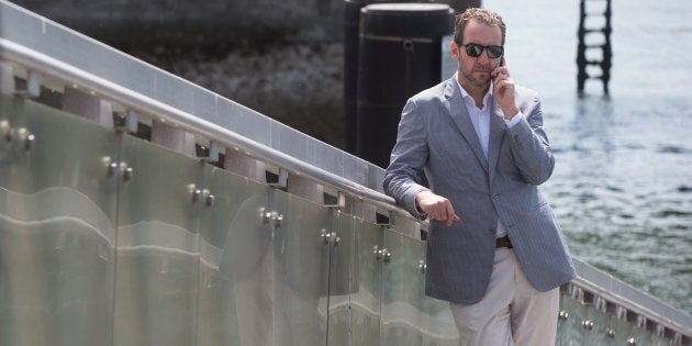 Gerald Butts speaks on his phone as Trudeau holds a news conference in North Vancouver, B.C., on May 29, 2015.