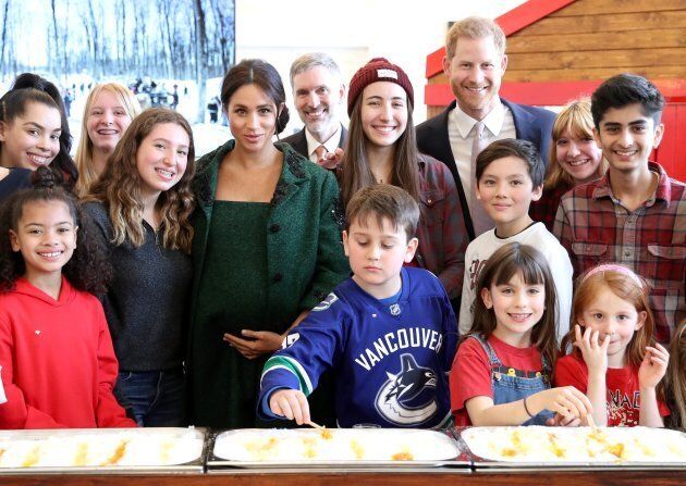 Harry and Meghan pose with kids. Check out that hero in the front!