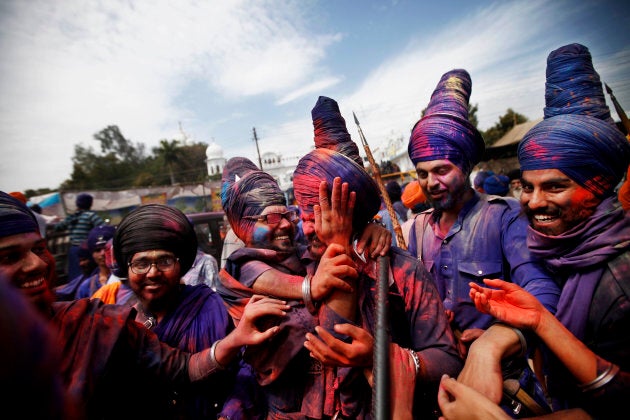 Nihangs (Sikh warriors) smear each other's faces with colour powder as they participate in a religious procession during the annual fair of Hola Mohalla in Punjab, India.