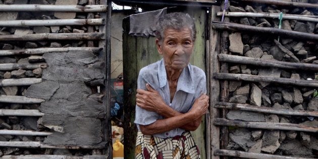 A shivering displaced woman is portrayed in the doorframe of a house in Beira on March 19, 2019. More than a thousand people are feared to have died in a cyclone that smashed into Mozambique last week.