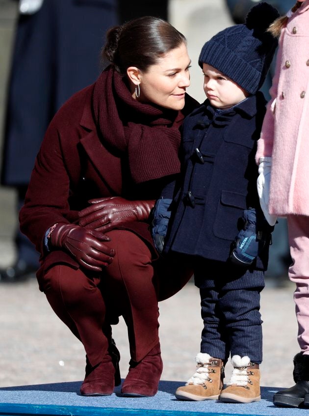 Crown Princess Victoria of Sweden, probably trying to bribe Oscar into smiling by promising him sweet, sweet candy after the ceremony. Prince Oscar, not taking the bait, holds out for a pony.