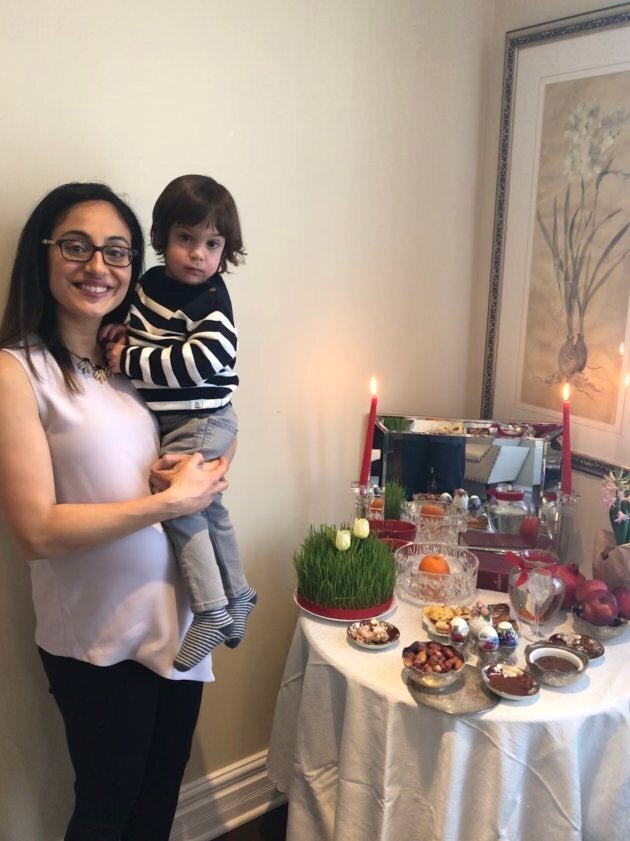 Leily Shafaee and her two-year-old son in front of their haft seen table this year.