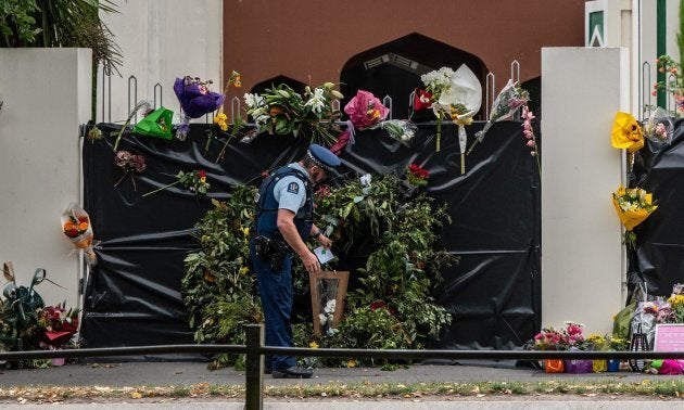 A policeman places flowers on the gates of Al Noor mosque in Christchurch, New Zealand on March 21.