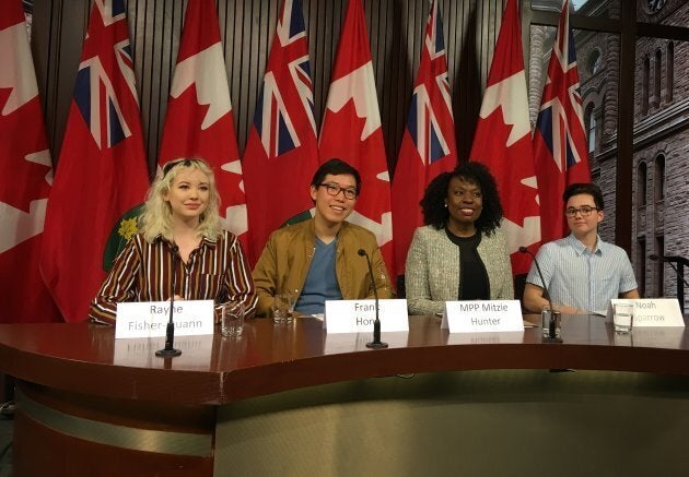 Students Rayne Fisher-Quann, Frank Hong and Noah Sparrow pose with Liberal MPP Mitzie Hunter at Queen's Park.