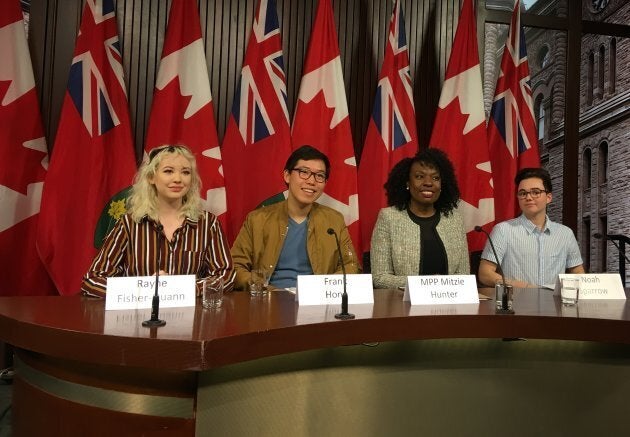 Students Rayne Fisher-Quann, Frank Hong and Noah Sparrow pose with Liberal MPP Mitzie Hunter at Queen's Park.