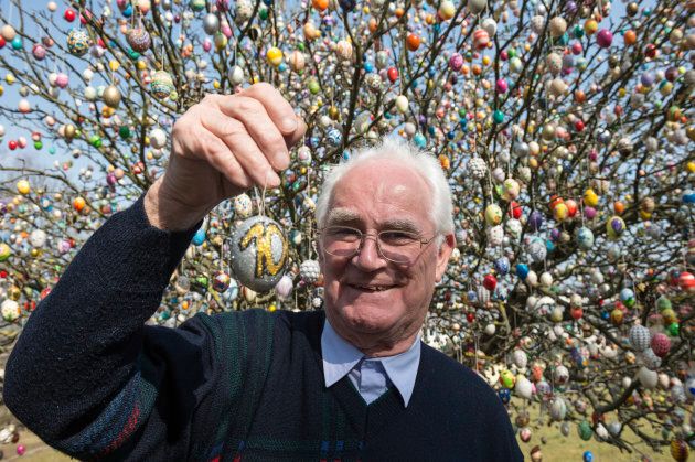 Pensioner Volker Kraft stands next to an apple tree decorated with approximately 10,000 Easter eggs on March 25, 2015 in Saalfeld, Germany.