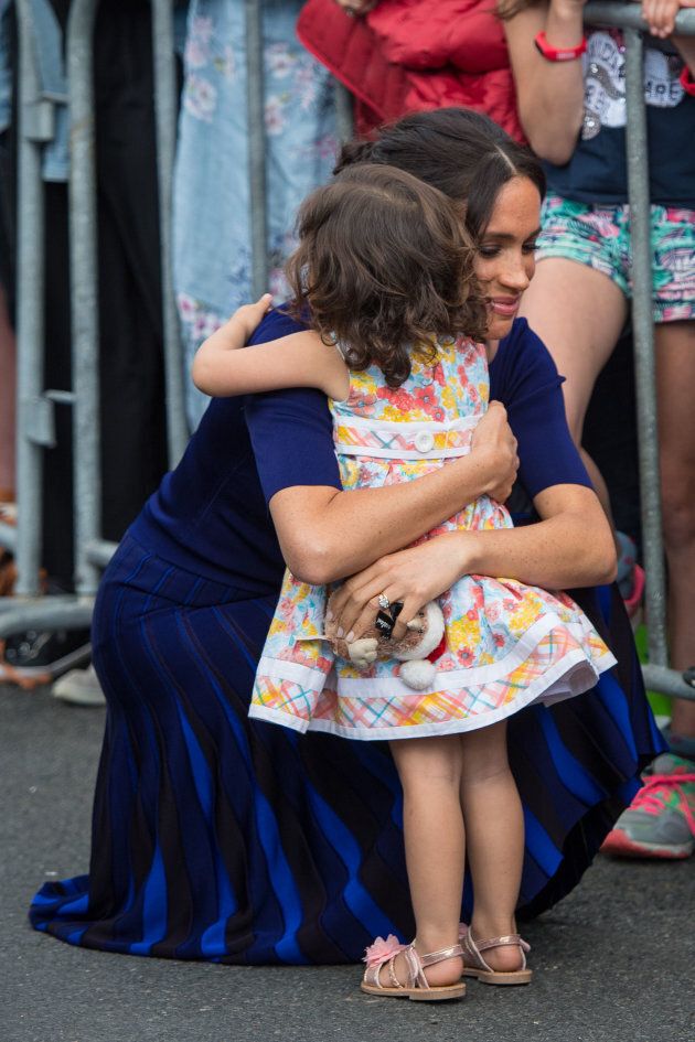 The Duchess of Sussex hugs a young girl during a walkabout in Rotorua on day four of the royal couple's tour of New Zealand.