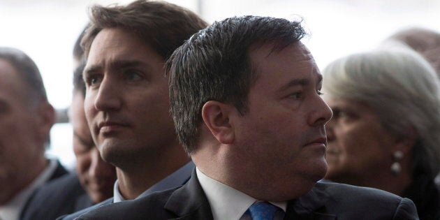 Jason Kenney looks around as he sits next to Justin Trudeau during an event in Ottawa on Jan. 27, 2015 in Ottawa.