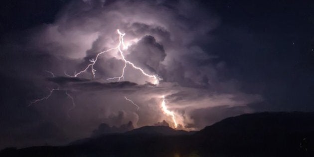 KARO, INDONESIA - FEBRUARY 21: A general view of spewing pyroclastic and thunderbolt during Mount Sinabung volcano eruption, seen from Tiga Pancur village on February 21, 2015 in Karo, North Sumatra, Indonesia. Areas of Tiga Pancur village and Payung village are covered with volcanic ash. (Photo by Tibt Nangin/Anadolu Agency/Getty Images)