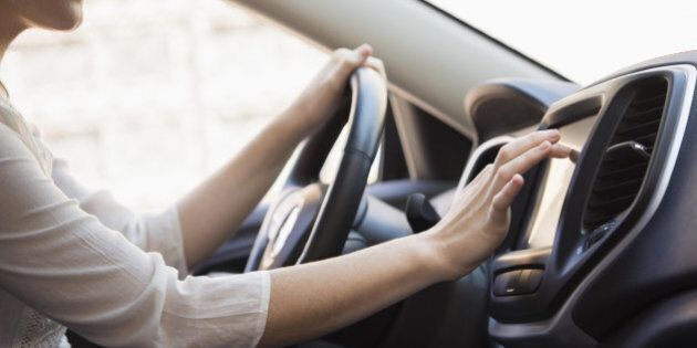 Caucasian woman using GPS system in car