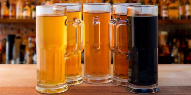 beer flight of five sampling mugs of light and dark craft beer in a bar