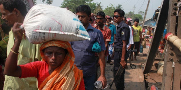 Bangladeshi Hindu devotes walk across a bridge to participate in a Hindu bathing ritual in Langalbandh, 20 kilometers (12 miles) southeast of capital Dhaka, Bangladesh, Friday, March 27, 2015. Local police chief Nazrul Islam said a stampede took place in a Hindu pilgrimage spot on the banks of the Brahmaputra river during an annual religious bathing ritual. (AP Photo/ A.M. Ahad)