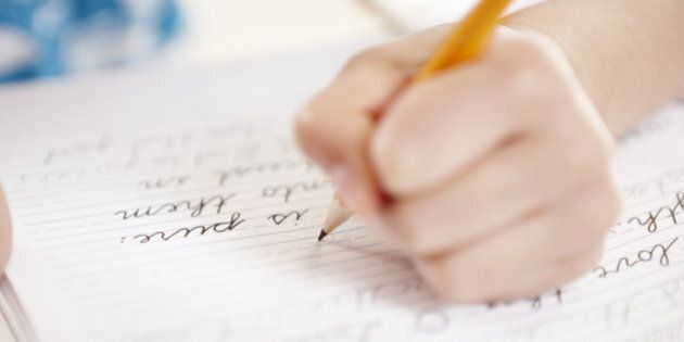 Close-up of girls hand writing on notebook