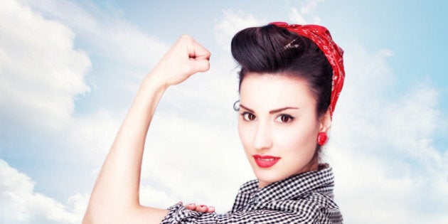 Brunette striking a famous Rosie Riveter pose