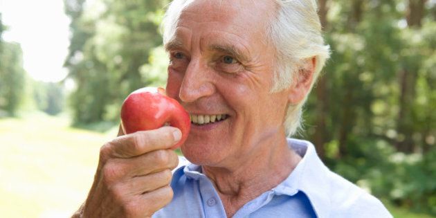 Elderly man eating an apple
