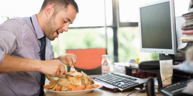 man eating large meal at a desk