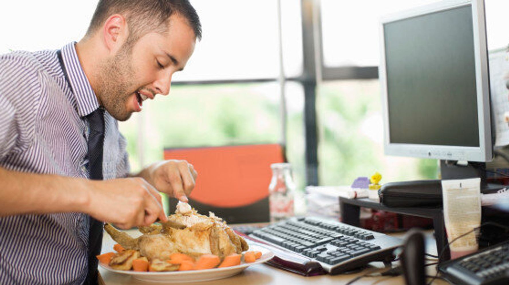 Человек ест за компьютером
