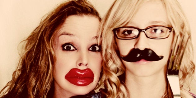 Mother daughter portrait wearing Halloween wax lips and Halloween wax mustache.