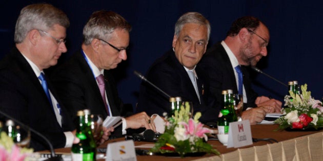 Chilean President Sebastian Pinera, second left, and Canadian Prime Minister Stephen Harper, left, attend the Trans-Pacific Partnership meet in Bali, Indonesia, Tuesday, Oct. 8, 2013. Leaders of the dozen countries involved in the U.S.-led Trans-Pacific Partnership met in Bali after the Asia-Pacific Economic Cooperation (APEC) summit to work on plans for a free trade area they hope will eventually encompass the entire region. (AP Photo/Wong Maye-E)