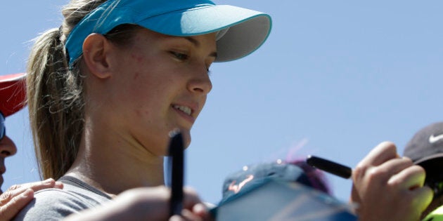 Eugenie Bouchard of Canada signs autographs for fans during a training session at the Australian Open tennis championship in Melbourne, Australia, Wednesday, Jan. 22, 2014. Bouchard faces Li Na of China in the women's singles semifinal Thursday.(AP Photo/Aijaz Rahi)