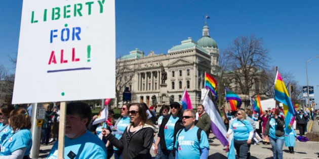 Opponents of Indiana Senate Bill 101, the Religious Freedom Restoration Act, march past the Indiana Statehouse en route to Lucas Oil Stadium in Indianapolis on Saturday, April 4, 2015 to push for a state law that specifically bars discrimination based on sexual orientation or gender identity. (AP Photo/Doug McSchooler)