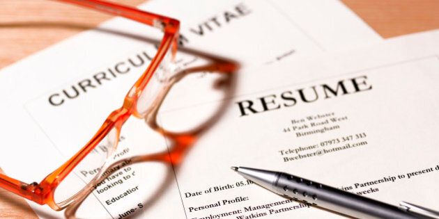 CV and resume with glasses and pen.