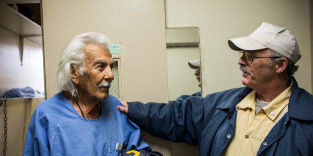 SAN LUIS OBISPO, CA - DECEMBER 19: (Editorial Use Only) Anthony Alvarez (L), age 82, talks to Phillip Burdick, a fellow prisoner and member of the Gold Coats program at California Men's Colony prison on December 19, 2013 in San Luis Obispo, California. The Gold Coats program is a volunteer care program where healthy prisoners volunteer to take care of elderly prisoners who either need general assistance with mobility and every day life or who also struggle with Alzheimer's and dementia. The program, the first of it's kind in the country, has existed for approximately 25 years. According to Alvarez, he has been incarcerated for 42 years due to a series of burglaries, possession of illegal firearms and escapes from county jail. Eventually these convictions led to him getting a life sentence due to three-strike laws. 'I never shot anyone,' Alvarez said, 'I had the chance but I could never shoot anyone.' Today is Alvarez's first day being assisted by the Gold Coats; he largely needs help with mobility. Alvarez tries to work out for a few minutes every other day. He says he would like to apply for compassionate release, a program where prisoners are released from prison after being found no longer a threat to society, or if a doctor deems that they are within the last six months of their life. Phillip Burdick, age 62, has been volunteering with the Gold Coats for over 18 years - he is the longest serving member of the Gold Coats. Burdick, who says he became a Christian in prison over 30 years ago, has served 37 years on a 7-years-to-life sentence for first degree murder. 'Being a Christian man, I know God has a plan for everything,' Burdick says. When asked why he joined the Gold Coats he responds, 'I was attracted to helping other less fortunate than myself - I can't imagine doing anything better in prison.' He hopes to work in a similar line of work if he is released. (Photo by Andrew Burton/Getty Images)