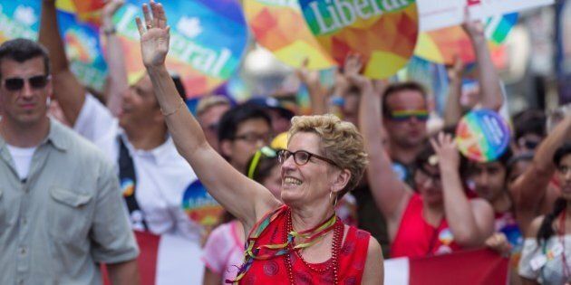 Ontario Premier Kathleen Wynne , the first openly gay premier of Ontario, waves as she marches in the WorldPride 2014 Parade in Toronto, Canada, June 29, 2014. WorldPride is an event that promotes lesbian, gay, bisexual and transgender (LGBT pride) issues on an international level through parades, festivals and other cultural activities. 2014 host Toronto is the first WorldPride celebration ever held in North America, and the 4th such festival in the world. AFP PHOTO / Geoff ROBINS (Photo credit should read GEOFF ROBINS/AFP/Getty Images)