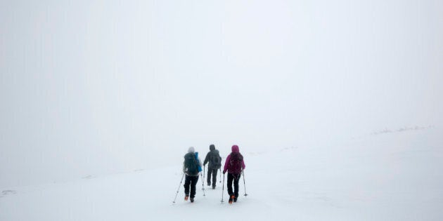 In this Saturday, April 5, 2014 photo, climbers Ania Kowalczyk, Marielle Bergeron and Lucy Bergeron, all of Quebec City, search for a trail marker during a whiteout caused by freezing fog, less than a mile from the summit of Mount Adams in New Hampshire. Winter weather, which often lasts well into spring in the Presidential Range, prompted the group to turn back. (AP Photo/Robert F. Bukaty)