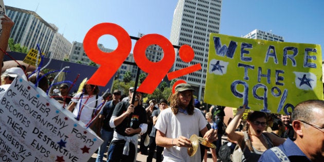 LOS ANGELES, CA - OCTOBER 01: Protesters hold signs as they march to Los Angeles City Hall during the 'Occupy Los Angeles' demonstration in solidarity with the ongoing 'Occupy Wall Street' protest in New York City on October 1, 2011 in Los Angeles, California. The protesters slogan, 'We are the 99 percent,' calls attention to the fact that marchers are not part of the 1 percent of Americans who hold a vast portion of the nation's wealth. (Photo by Kevork Djansezian/Getty Images)